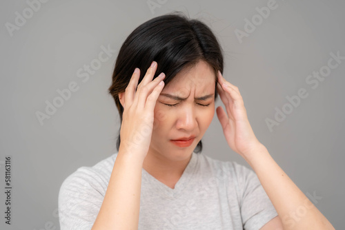 Asian woman holding her temple and making a bad face. woman having migraine headache © Worranan