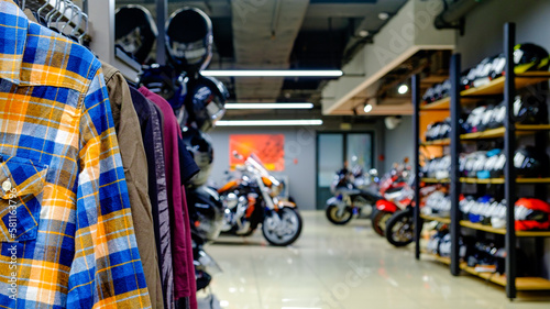 Inside the motorcycle store. Clothing, helmets, motorcycles. Focus on the foreground
