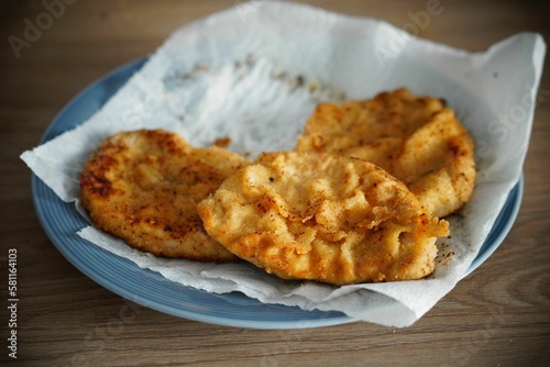 Closeup of deep-fried chicken breast served on a blue plate