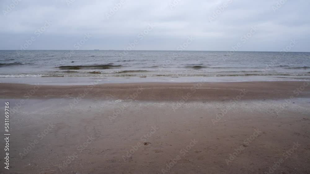 Scenic view of of the sea waves washing the shore on a cloudy day Scenic view of of the sea waves washing the shore on a cloudy day