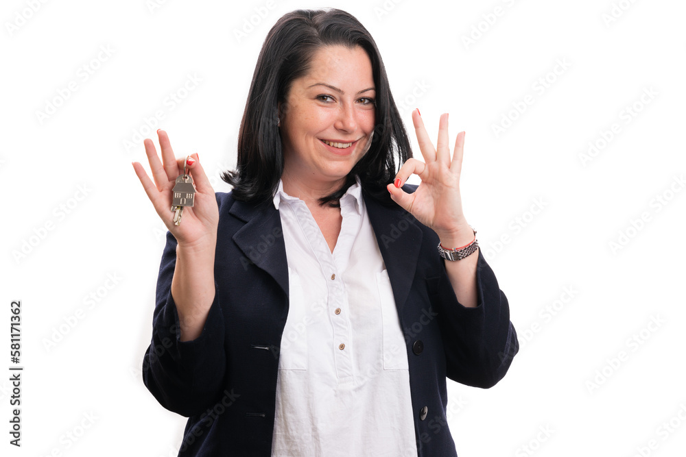 Real-estate agent holding keys making okay gesture using fingers Real-estate agent holding keys making okay gesture using fingers