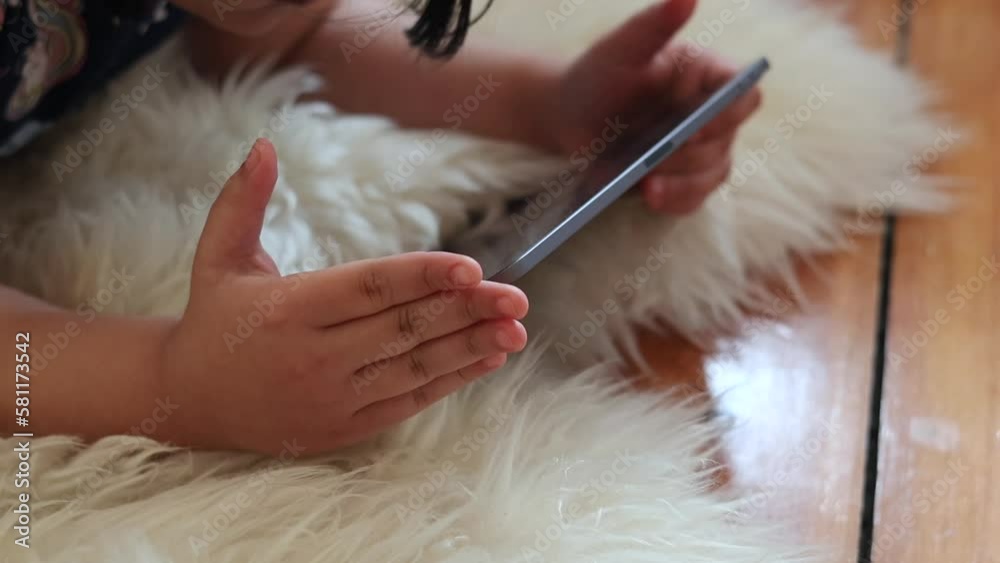 Close up of Asian child playing and watching on a tablet for e learning in school Close up of Asian child playing and watching on a tablet for e learning in school