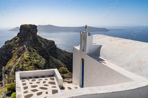 Traditional white Greek church with an amazing view over Sakros rock in Santorini, Greece