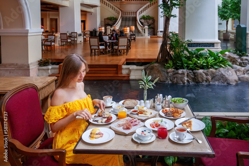 Elegant Woman Enjoying a Fine Dining Experience in a Luxury Restaurant  dressed in a sophisticated outfit and surrounded by an elegant decor