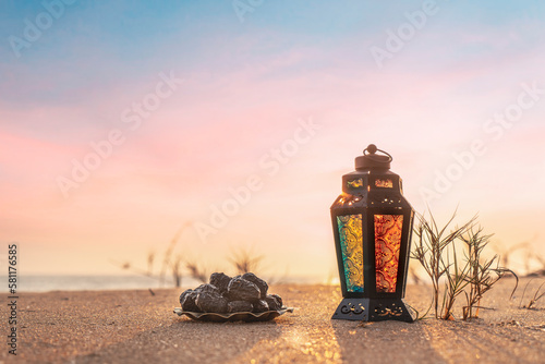 Iftar concept image lantern lamp with dates on the beach photo