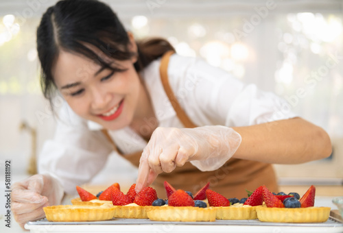 Freshly baked tart with blueberries strawberry fresh fruit kitchen for dessert.Young beautiful woman is baking in kitchen   bakery and coffee shop business.  bakery and coffee shop business.