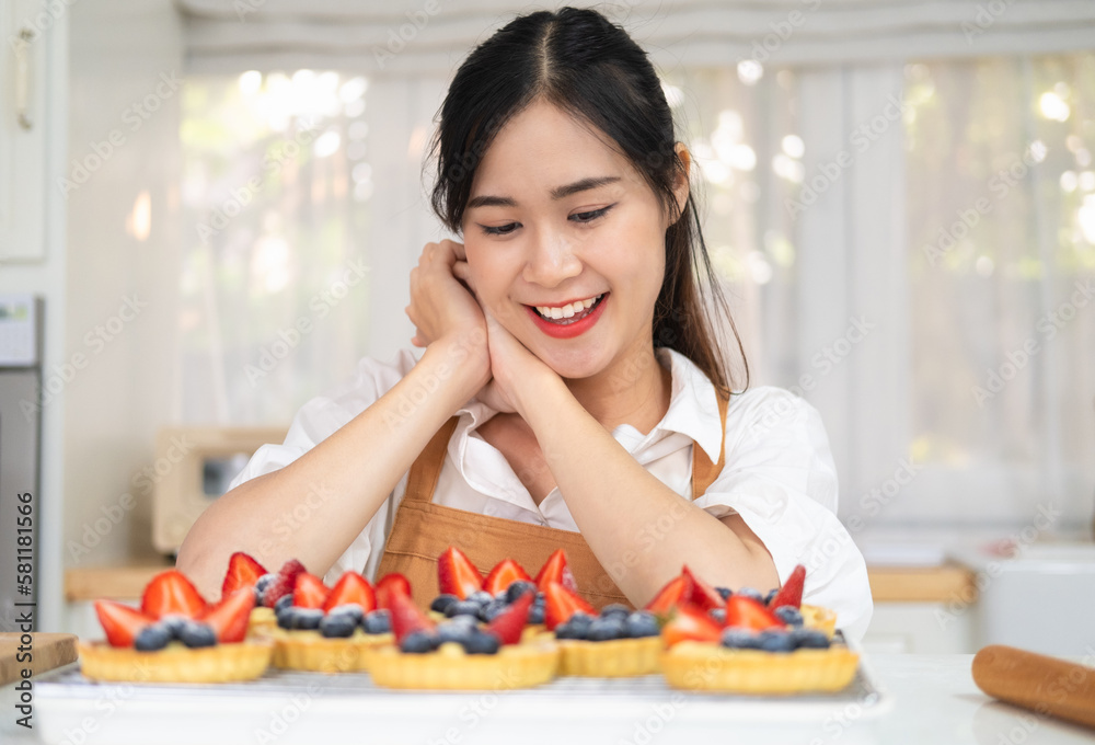 Young beautiful woman is baking in kitchen , bakery and coffee shop business. Freshly baked tart with blueberries strawberry fresh fruit. bakery and coffee shop business.