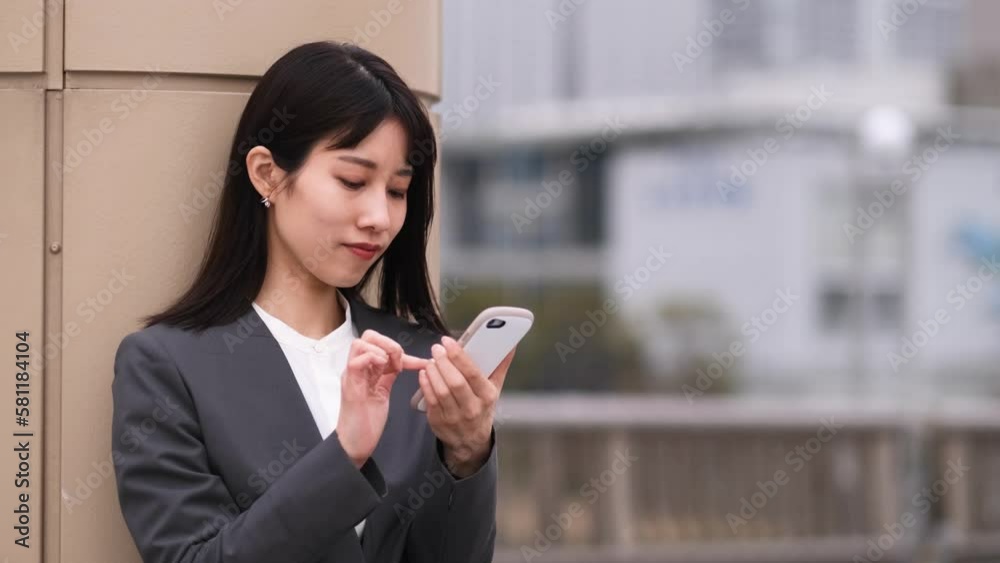 スマートフォンでメールを打つビジネスウーマン