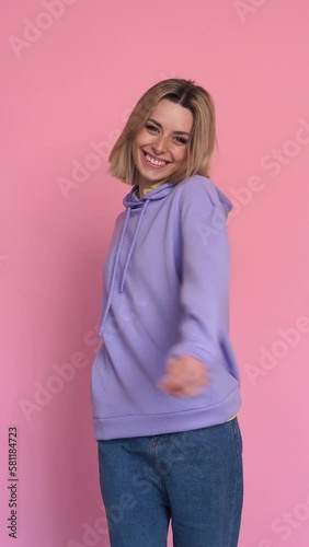 Cheerful young woman smiling and looking at camera. Vertical video.
