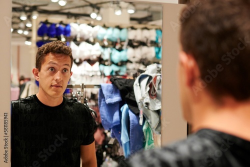 Hispanic man posing in front of a mirror in a clothing store