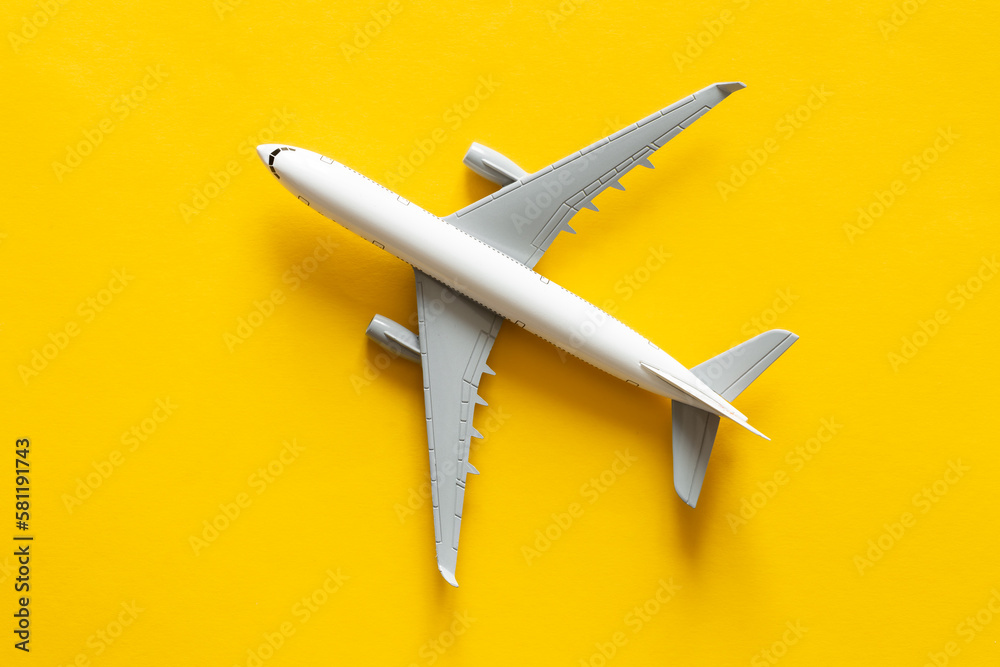 Airplane model on yellow background isolated, flat lay, air ticket, travel and vacation concept.