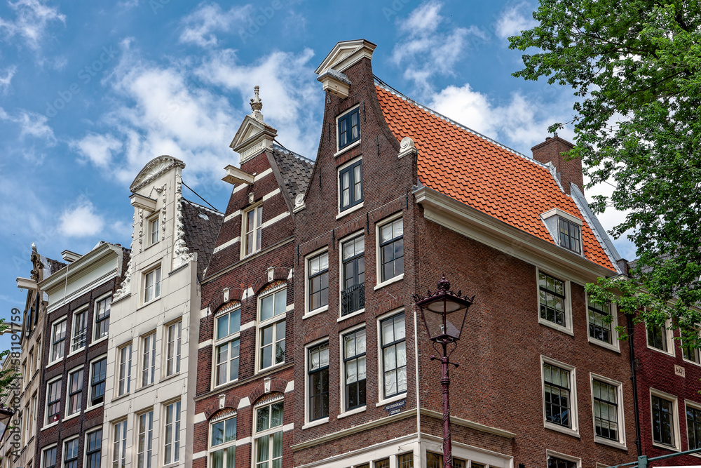 Amsterdam street in summer with colorful houses in classic holland architecture