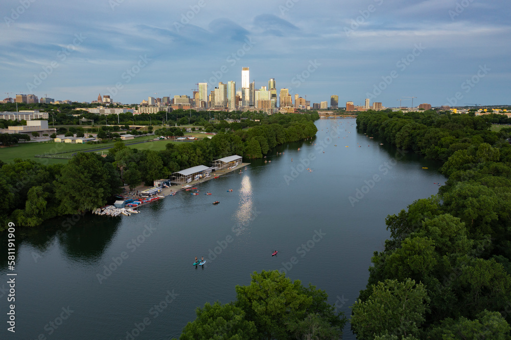 Austin, Texas skyline and cityscape with Lady Bird Lake and stand up paddleboard on the river water during golden hour sunset