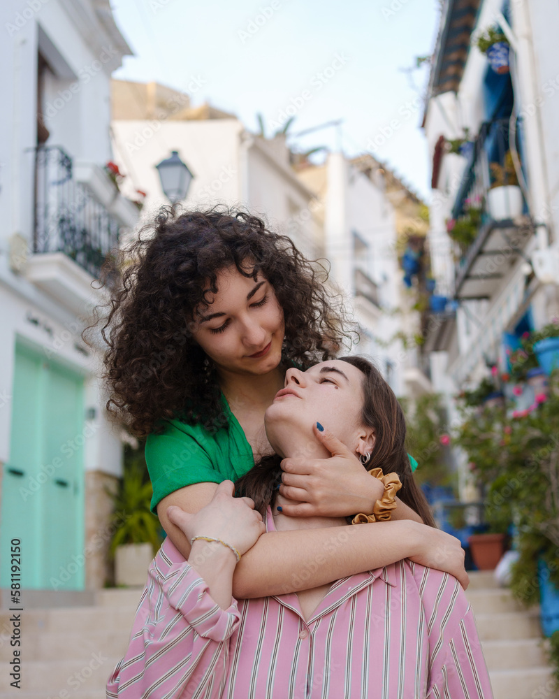 Fototapeta premium two lesbian girls in love walk happily through the city on gay pride day