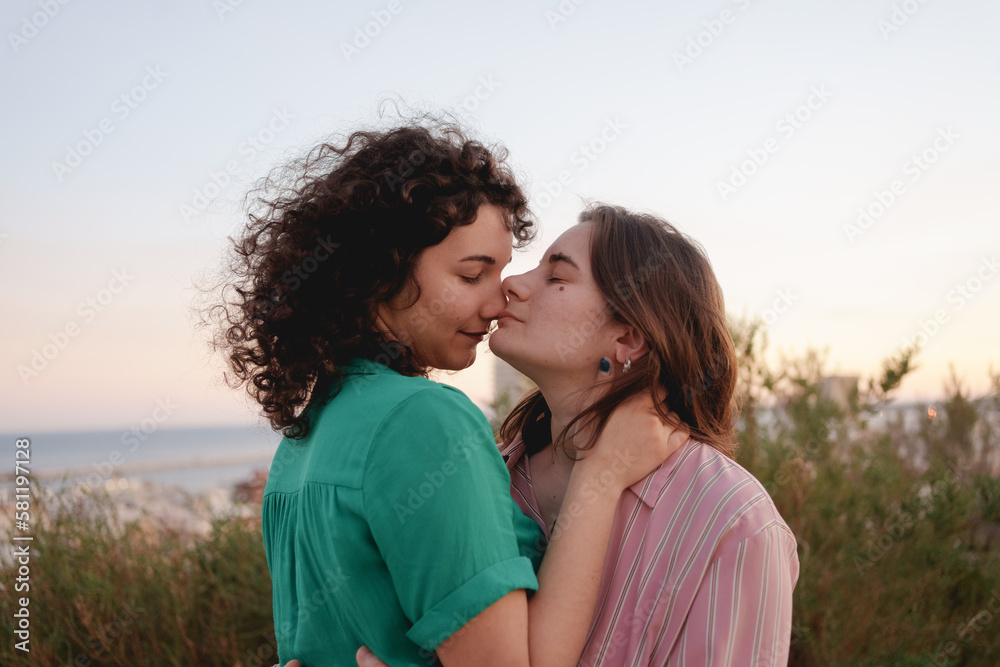 two lesbian girls in love watch the sunset on gay pride day two lesbian girls in love watch the sunset on gay pride day