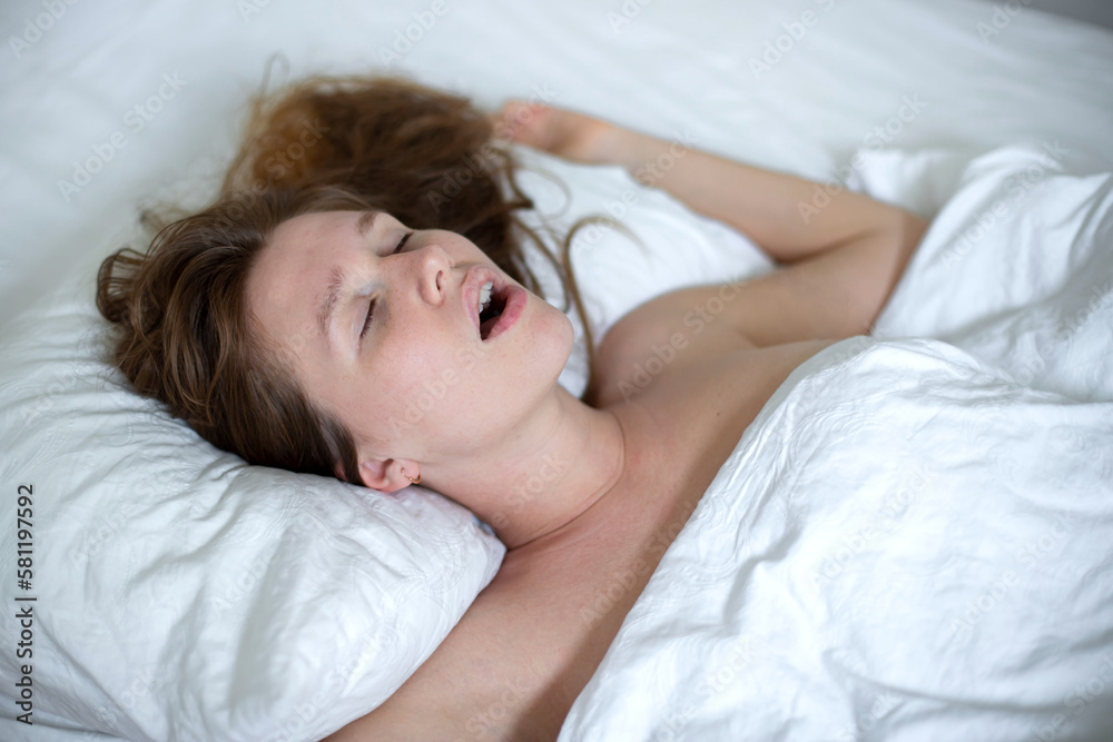 young girl sleeps in the morning in bed and snores loudly with her mouth open, the concept of person have problem with sleep and breathing young girl sleeps in the morning in bed and snores loudly with her mouth open, the concept of person have problem with sleep and breathing