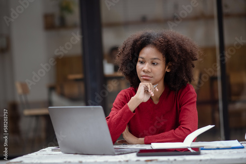Young African American businesswoman working with laptop at cafe.