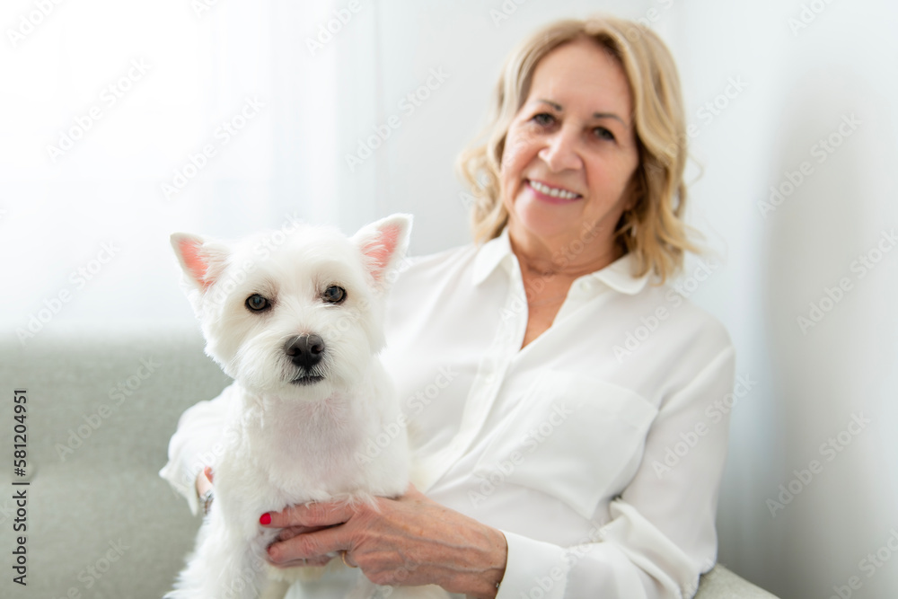 Cheerful retired senior woman with dog and enjoying time with pet at home Cheerful retired senior woman with dog and enjoying time with pet at home