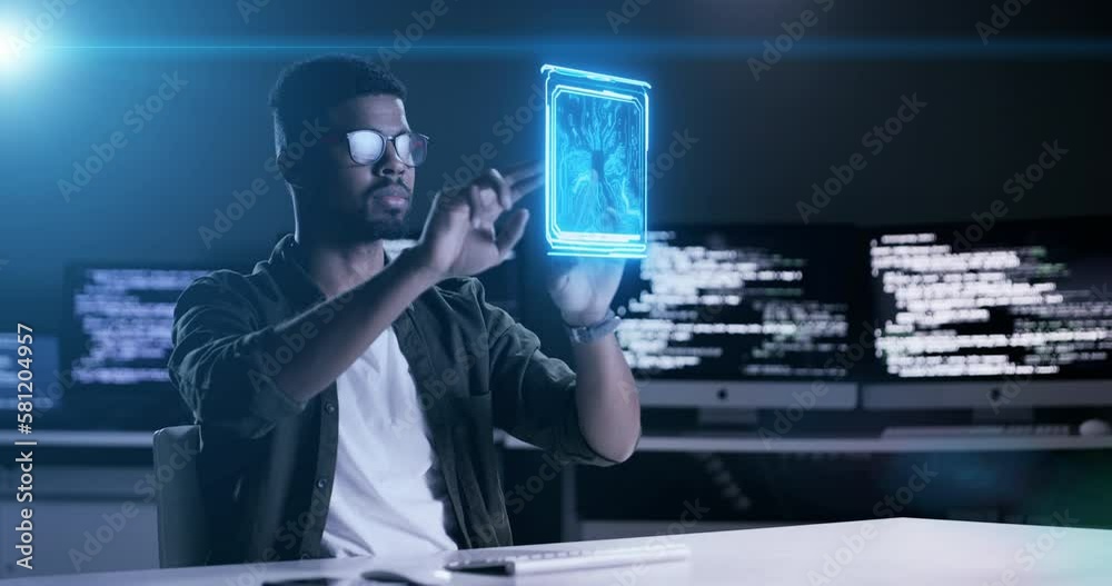 Man, programming and futuristic hologram at night on computer dashboard or software application at office. Male programmer working late on future AI technology or virtual app for UI or UX overlay
