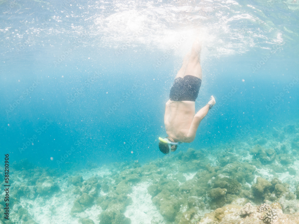man snorkeling in crystal clear tropical sea