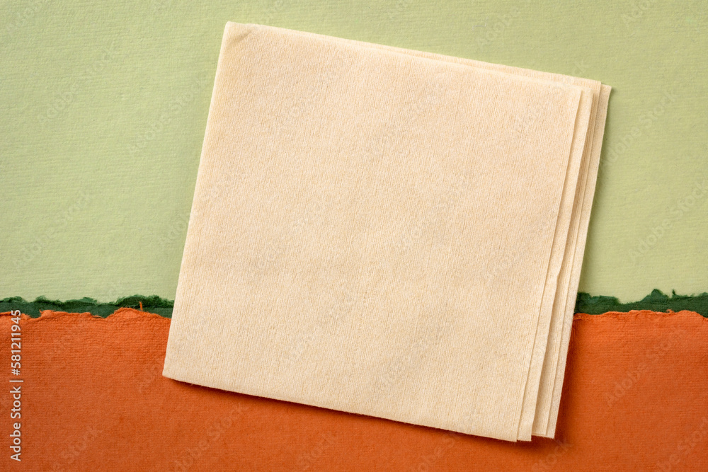 Fototapeta premium blank napkin against abstract paper landscape in green and orange tones