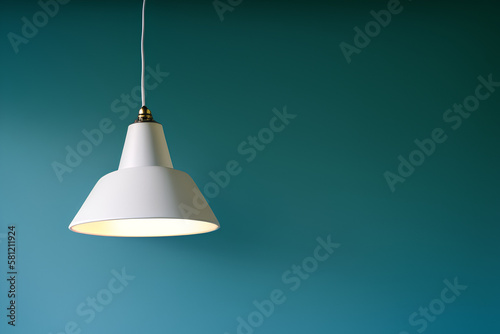 Lamp with a white lampshade hanging on the cable in a room with soft background photo