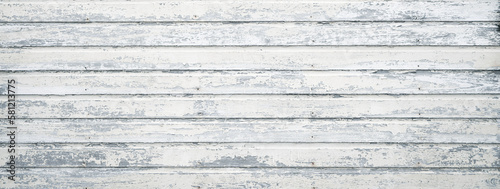 Old house exterior with old wooden boards. White painted wood siding with antique finish.
