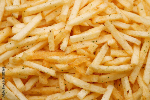 French fries background, closeup shot. Delicious potatoes with a golden fried crust. French fries background. Potato straw