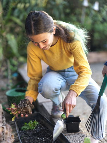 Girl planting vegetables in garden