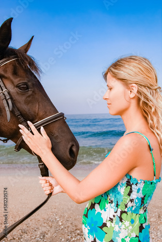 Happy pregnant woman with a horse on the beach in the summer on the nature