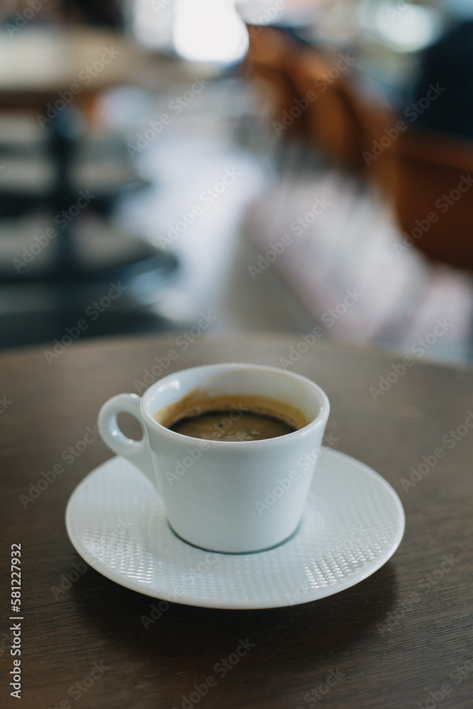 Cup of black coffee on a table in a cafe. Selective focus.