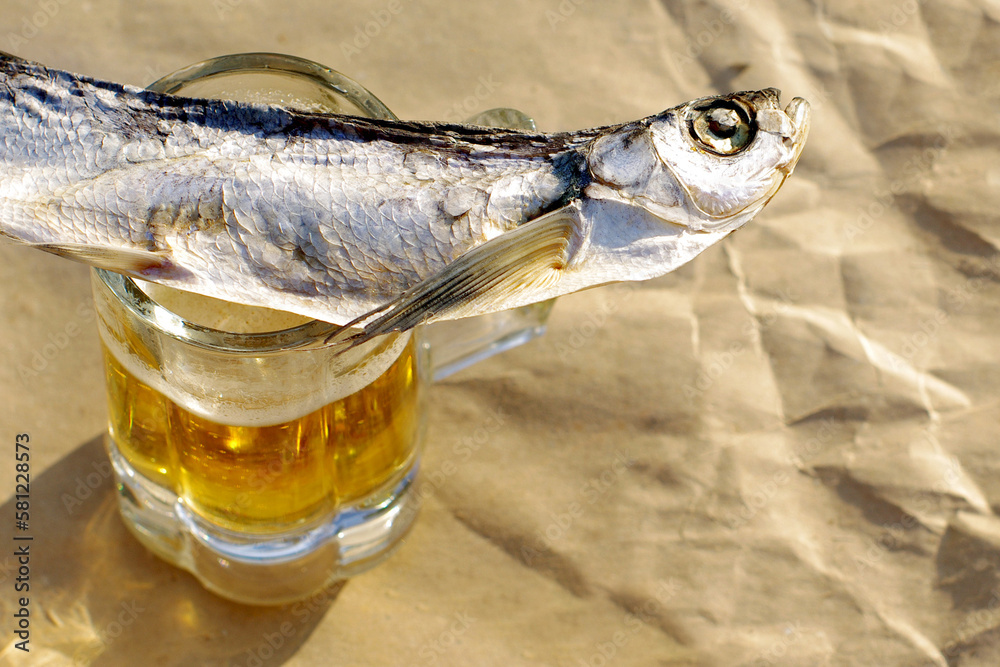 Dry salted river fish sabrefish (Pelecus cultratus) and a glass of