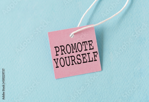 Promote Yourself text quote on a pink card, Business Concept on Blue Background.