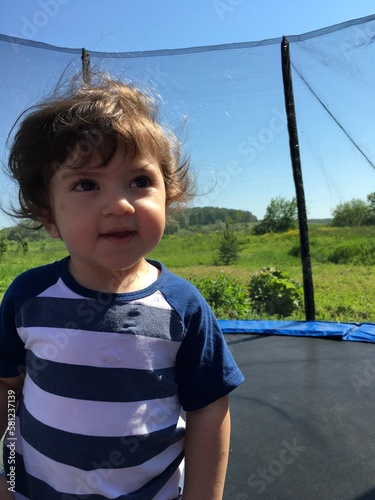 smiling happy joyful child on the playground swinging on the trampoline