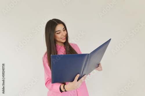 Happy young woman holding a blue folder at the office