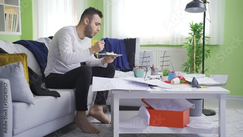 Lazy messy man eating at home.
The messy and lazy man lives in the dirty house and is content with his life.
