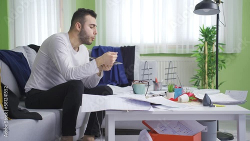 Lazy man is happy and eating his meal in his messy house.
A young man with a messy house is content and relaxed with pollution.
