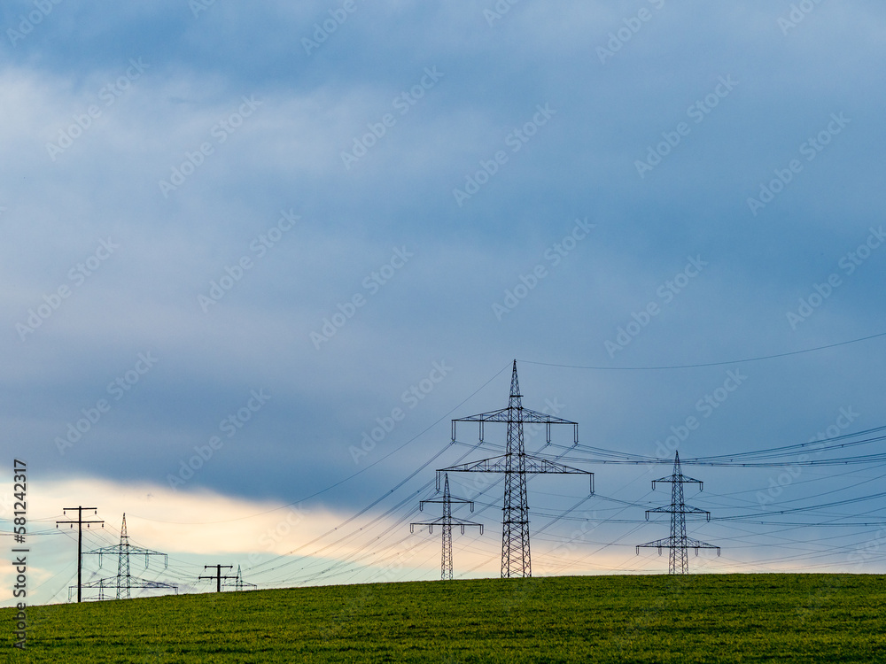 Strommasten einer Überlandleitung unter bewölktem Himmel Strommasten einer Überlandleitung unter bewölktem Himmel