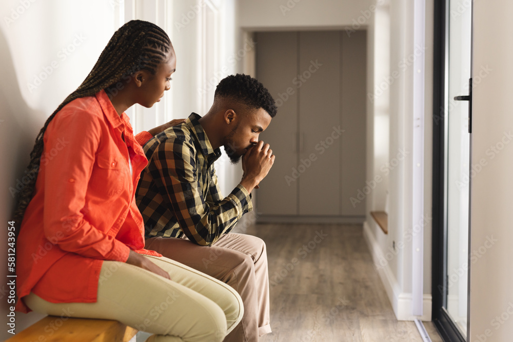 Sad african american couple sitting on wooden bench in hall Stock Photo ...