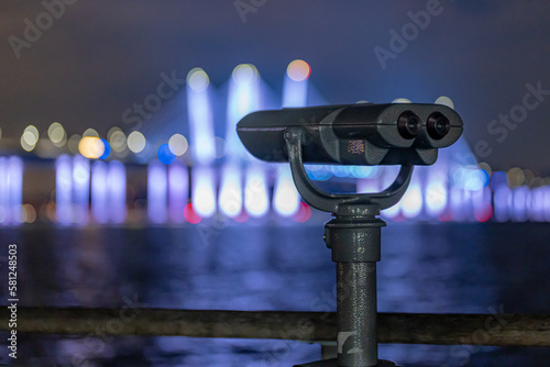 Tarrytown, NY - USA - February 2, 2023: Binoculars at Tarrytown Overlook with the Governor Mario M. Cuomo Bridge and Hudson River in the background.