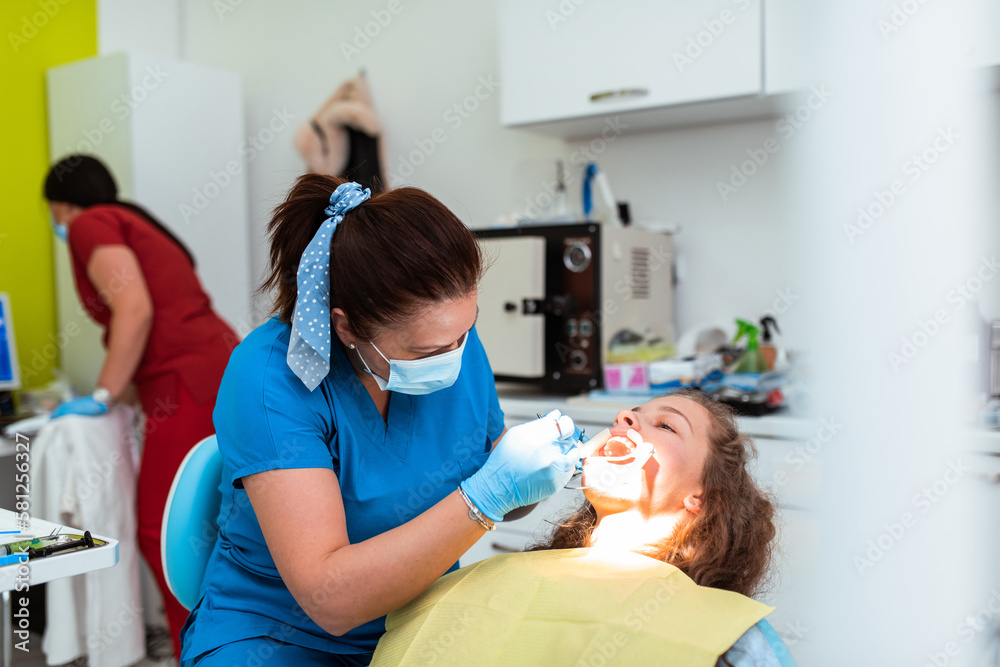 Dentist appointment at a dental clinic, placing braces locks on the teeth and pulling the archwire to fix it Dentist appointment at a dental clinic, placing braces locks on the teeth and pulling the archwire to fix it