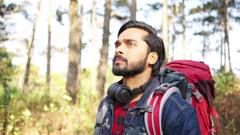 4K Indian man backpacker hiking in forest. Handsome guy traveler enjoy adventure activity outdoor lifestyle walking mountain dirt road on summer holiday vacation. Ecotourism and solo travel concept. 4K Indian man backpacker hiking in forest. Handsome guy traveler enjoy adventure activity outdoor lifestyle walking mountain dirt road on summer holiday vacation. Ecotourism and solo travel concept.