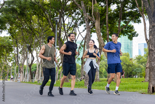 Group of Man and woman friends in sportswear jogging exercise together at public park in the morning. Healthy people athlete enjoy outdoor activity sport training fitness running workout in the city.