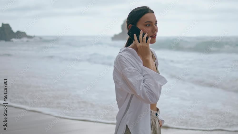 Girl speaking telephone ocean waves close up. Woman talking phone on beach. Girl speaking telephone ocean waves close up. Woman talking phone on beach.