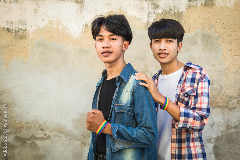 Gay couple love, Happy together concept. Two young Asian men standing together and smiling in concept of lgbt couple on old wall background.