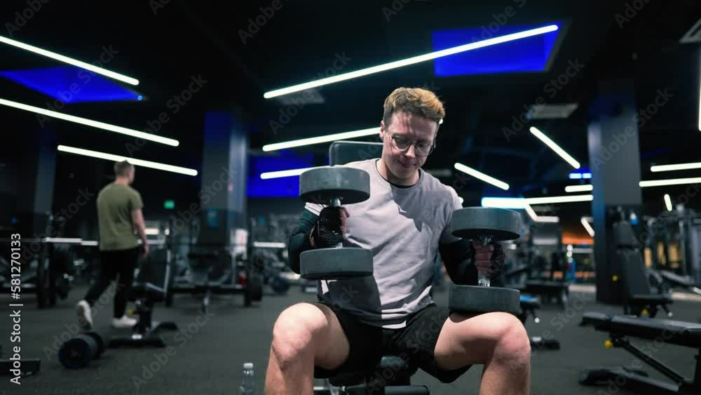 Fitness man trains with dumbbells in a modern gym, arm training
slow motion Fitness man trains with dumbbells in a modern gym, arm training
slow motion