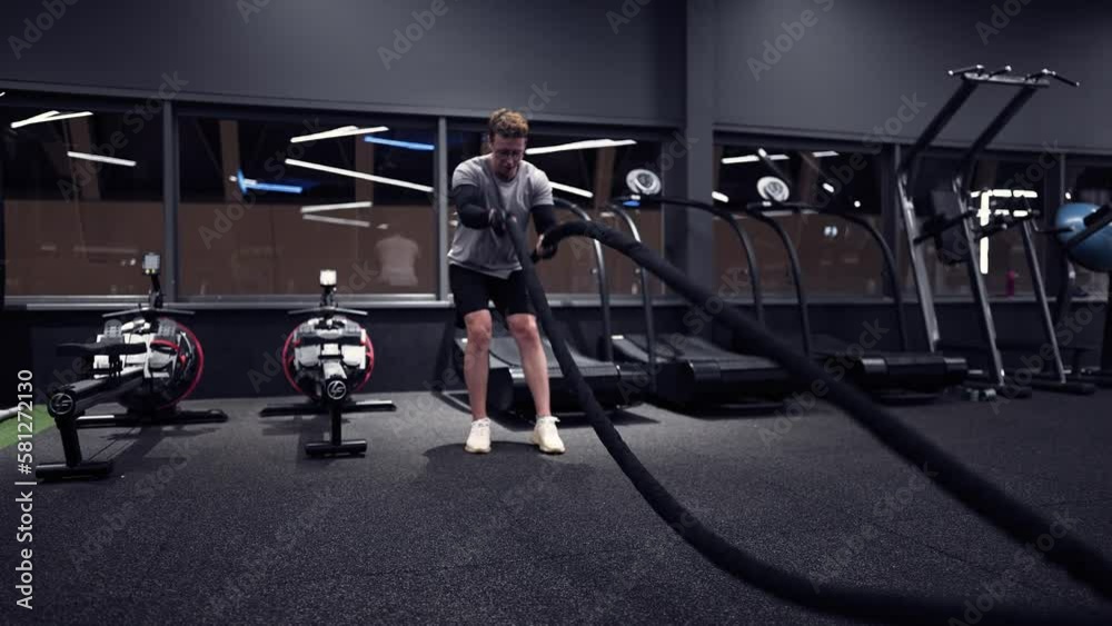 Fitness man exercising with battle ropes in a modern gym
slow motion Fitness man exercising with battle ropes in a modern gym
slow motion
