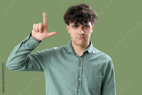 Young man making loser gest...