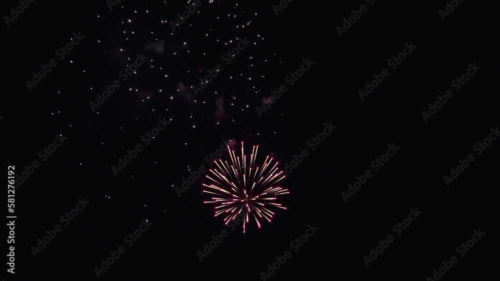 New years eve fireworks celebration. Glowing fireworks show. Beautiful multi colored fireworks in night sky. Shining fireworks with bokeh lights in night sky. Colored night explosions in black sky