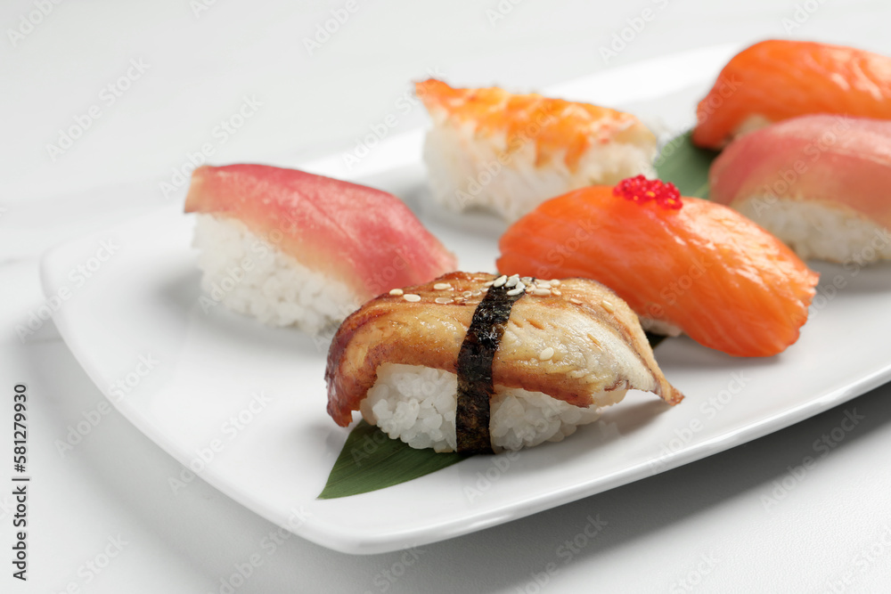 Plate with delicious nigiri sushi on white table, closeup Plate with delicious nigiri sushi on white table, closeup